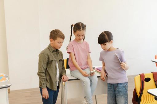 携帯を覗き込む生徒たち 男の子,女の子,子どもの写真素材