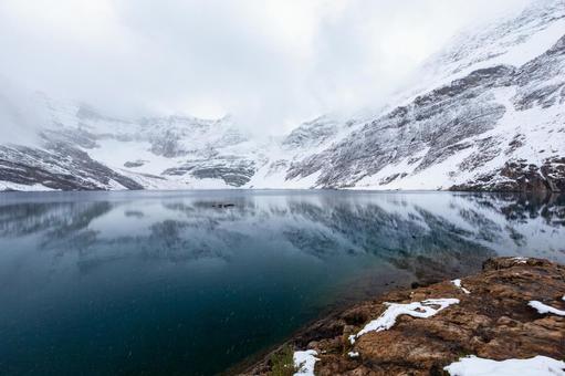 雪の湖畔と壮大な山岳風景 湖畔,荒涼,雪の写真素材