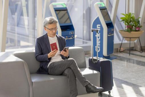 ミドル男性　空港　旅行 空港,ミドル,スマートフォンの写真素材