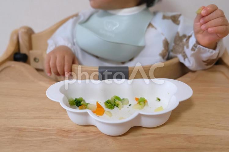 ハイチェアで離乳食を手づかみする子ども 手づかみ,離乳食,子どもの写真素材