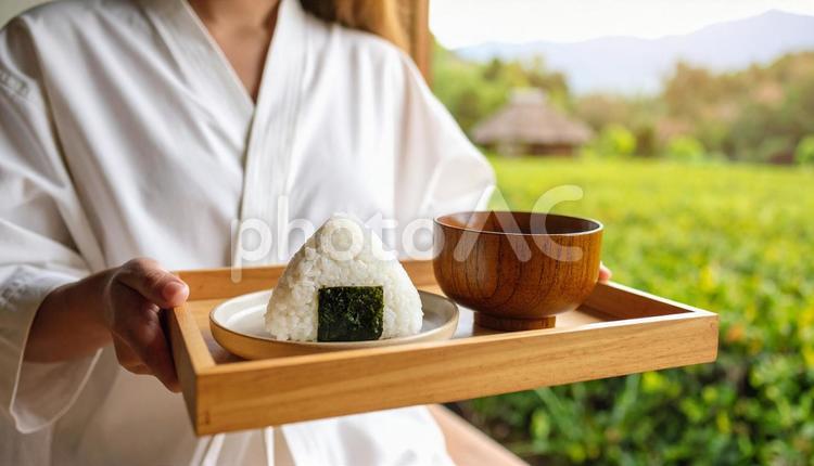 お盆に乗ったおにぎりと味噌汁を持つ女性 おにぎり,味噌汁,お盆の写真素材