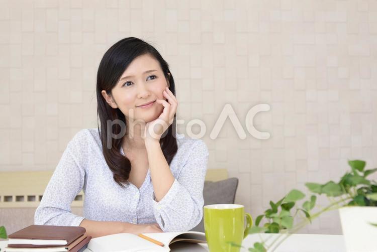 筆記用具を置いて考える女性 女性,主婦,ノートの写真素材