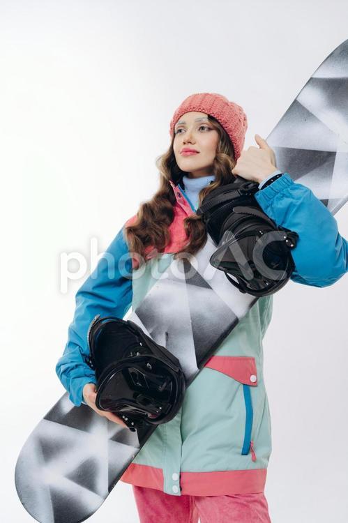スノーボードを抱えて持つ女性 スノーボードを抱えて持つ女性 冬,スポーツ,ウィンタースポーツの写真素材