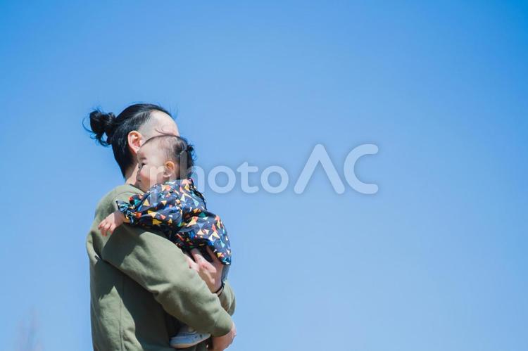 青空の下で娘を抱く父親 親子,家族,子供の写真素材