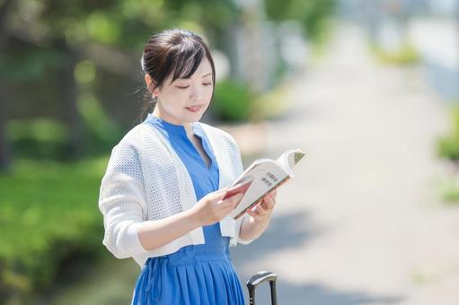 ガイドブックを見る笑顔の爽やかな女性 ガイドブックを見る笑顔の爽やかな女性 女性,笑顔,読書の写真素材