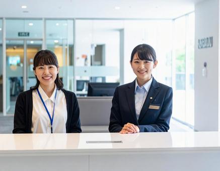 受付コーナー内に座る笑顔の受付嬢 受付コーナー内に座る笑顔の受付嬢の写真