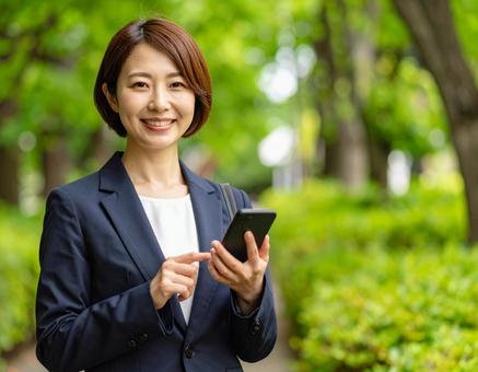 スマホを持っている女性 スマホを持っている女性の写真