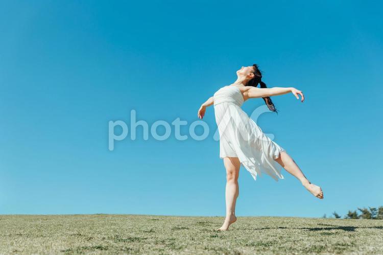 空と白いワンピースの踊る女性（アラベスク） ダンス,女性,空の写真素材