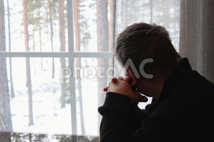 窓の外を見ながら物思いにふける男性 物思いにふける,考え事,悩むの写真素材