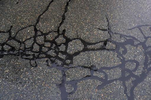 アスファルトのヒビ割れ補修（雨）02 アスファルト,道路,ヒビ割れの写真素材