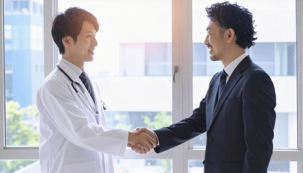 握手するビジネスパーソンと医者の写真