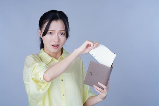 手帳から紙を出す黄色い服の女性 女性,手帳,ルーズリーフの写真素材