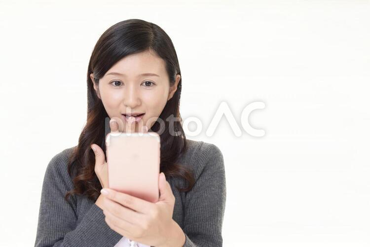 スマートフォンを持つ笑顔の女性 女性,スマートフォン,女の写真素材