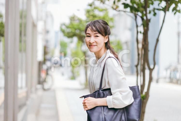 オフィス街を歩くワーキングマザー（通勤） ワーキングマザー,ワーママ,女性の写真素材