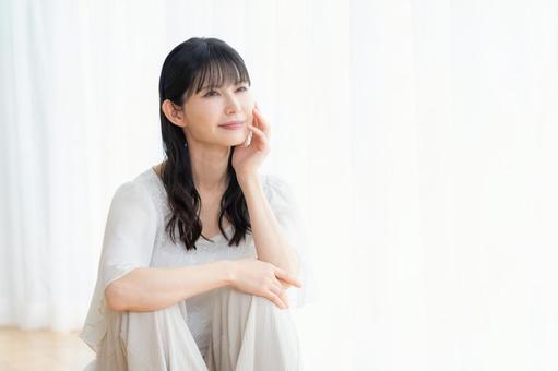 リビングでスキンケアをするミドルの女性 リビングでスキンケアをするミドルの女性 ビューティー,スキンケア,女性の写真素材