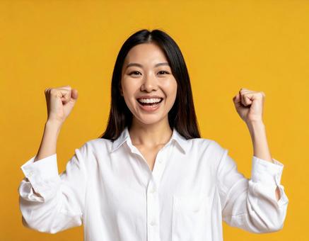 ガッツポーズで喜びを表現する日本人女性 ガッツポーズで喜びを表現する日本人女性の写真