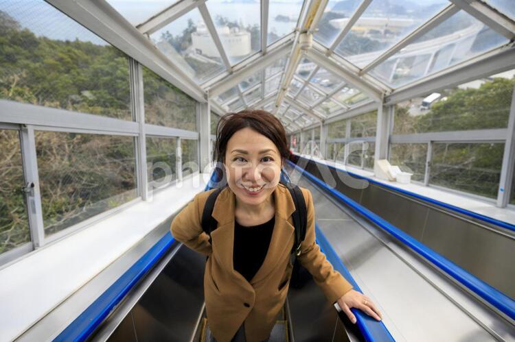 エスカレーターに乗る女性 女性,人物,日本人の写真素材