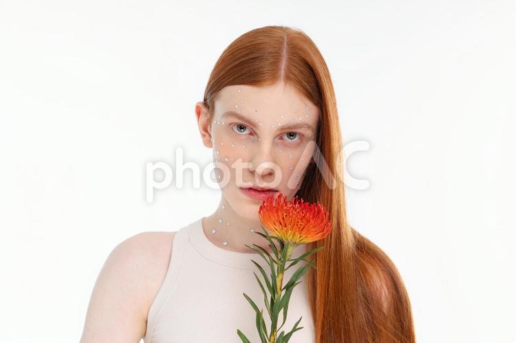 カメラ目線で赤い花を持つロングの女性 女性,花,ピンクッションの写真素材