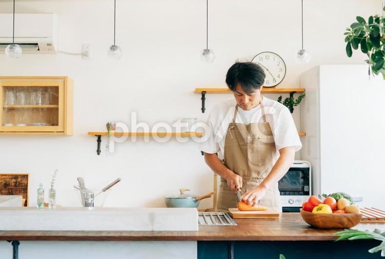 キッチンに立つ男性（野菜を切る） 料理,調理,自炊の写真素材