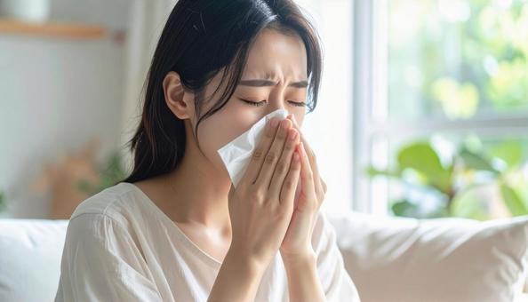 ティッシュで鼻をかむ日本人の若い女性 ティッシュで鼻をかむ日本人の若い女性の写真