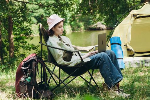 黒い椅子でリラックスして座る人物 女性,外国人,キャンプの写真素材