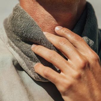 運動後の汗ばむ肌とタオルの写真