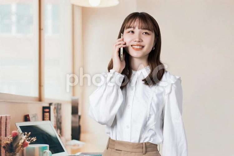 スマホで通話をする笑顔のビジネスウーマン 女性,ビジネス,スマホの写真素材