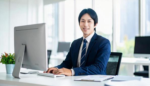 オフィスでパソコン使用した仕事をする男性 オフィスでパソコン使用した仕事をする男性の写真