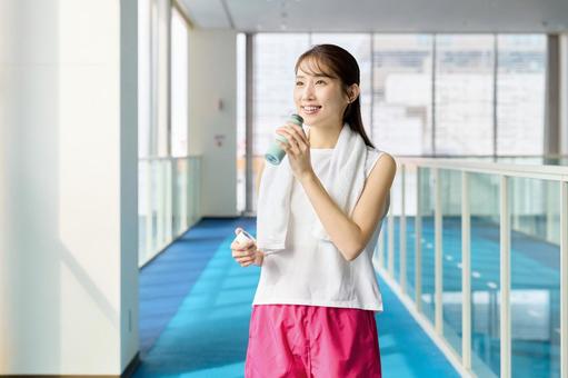 ジムで水分補給する女性 トレーニング,水分補給,女性の写真素材