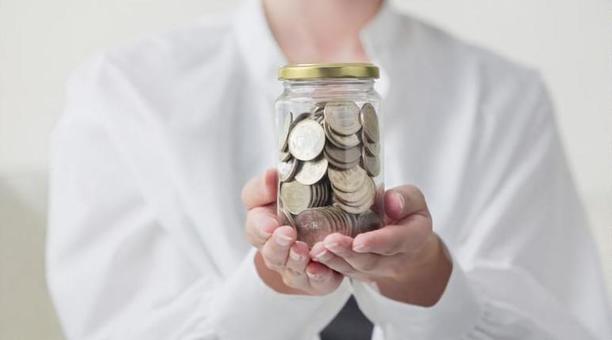 お金が入った瓶を持つアジア人女性の手元 貯金,500円玉,貯めるの写真素材