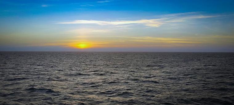 夕日が沈む水平線と広がる美しい海景色 夕日が沈む水平線と広がる美しい海景色の写真