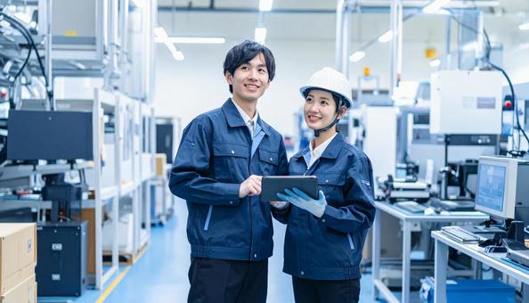 工場でタブレットで製品を検査する作業員 工場でタブレットで製品を検査する作業員の写真
