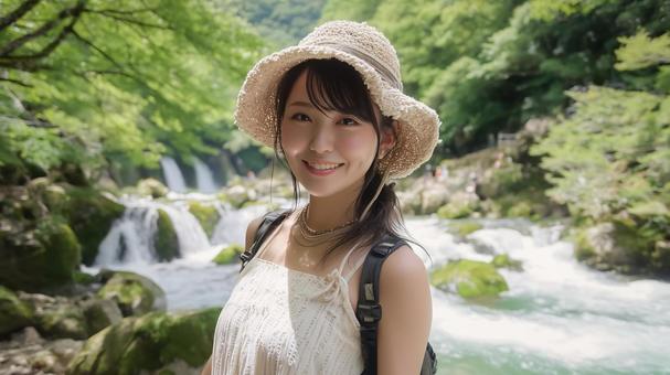 夏の渓流沿いの遊歩道に立つ若い日本人女性 夏の渓流沿いの遊歩道に立つ若い日本人女性の写真