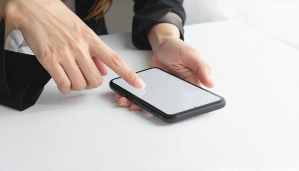 携帯を操作する女性の手元とノートパソコン 携帯を操作する女性の手元とノートパソコンの写真