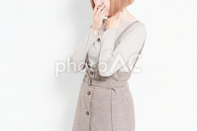 白背景の前に立って喉が痛いポーズをする若い女の子 喉,痛い,女の子の写真素材