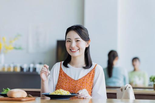 カフェで食事をする若い女性 カフェで食事をする若い女性の写真