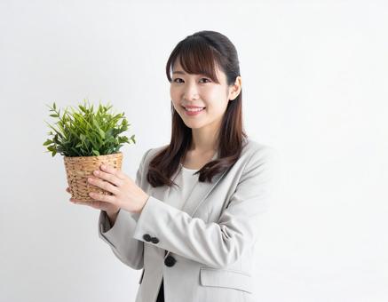 観葉植物を手にするビジネスパーソン 観葉植物を手にするビジネスパーソンの写真