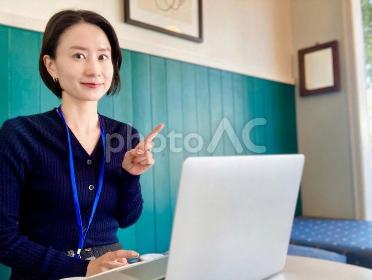 おしゃれカフェでポイントを説明する女性 女性,笑顔,カフェの写真素材