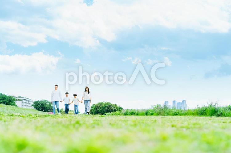 青空の草原を歩く家族 家族,笑顔,青空の写真素材