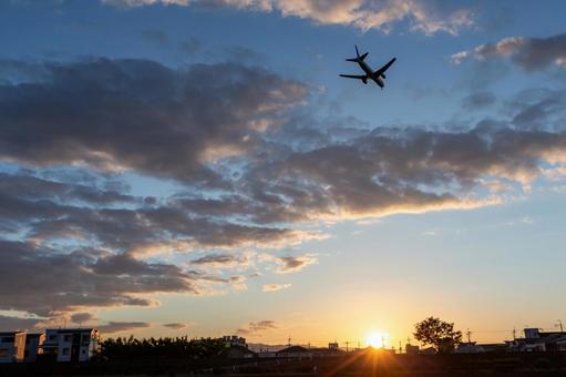 夕焼け空に着陸する飛行機 飛行機,シルエット,夕日の写真素材