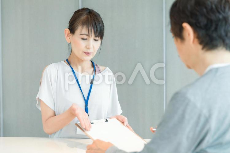 スポーツジムの受付をする女性（記入） スポーツジム,受付,スタッフの写真素材