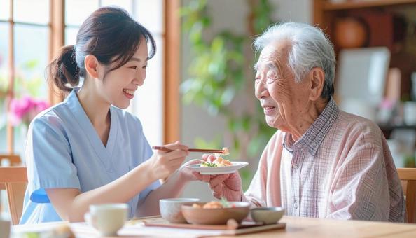 食事介助をする女性介護士と高齢男性 食事介助をする女性介護士と高齢男性の写真