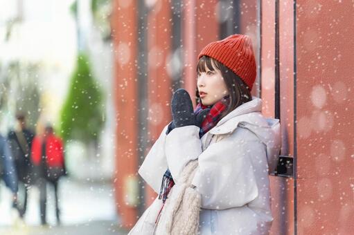 雪の降る冬の街角に立つ笑顔の女性 冬,雪,女性の写真素材