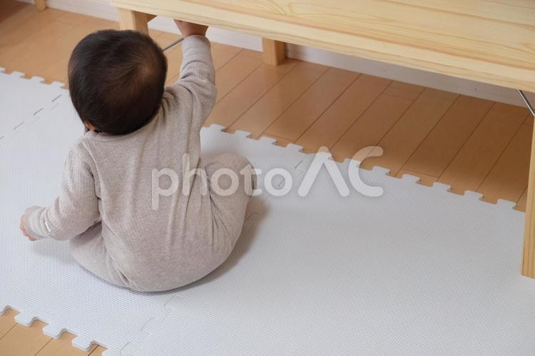 ローテーブルとおすわりしている赤ちゃん つかまり立ち,赤ちゃん,つかまるの写真素材