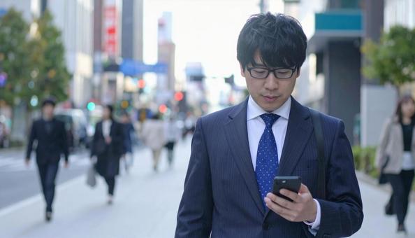 スマホを操作するビジネスマン スマホを操作するビジネスマンの写真
