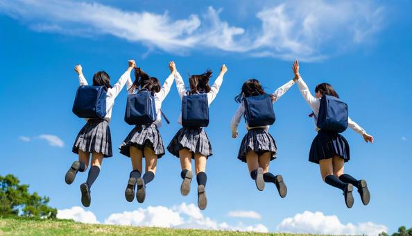 青空に向かってジャンプする生徒達の後ろ姿 青空に向かってジャンプする生徒達の後ろ姿の写真