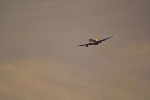 離陸する飛行機と夕焼け 離陸する飛行機と夕焼けの写真