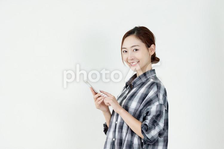 スマホを操作する笑顔の女性 女性,スマホ,キャッシュレスの写真素材