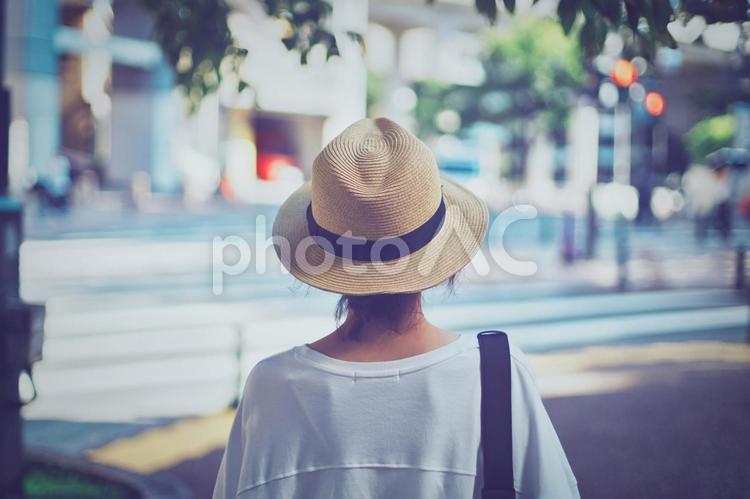 街を歩く麦わら帽子の女性後ろ姿 麦わら帽子,人物,女性の写真素材