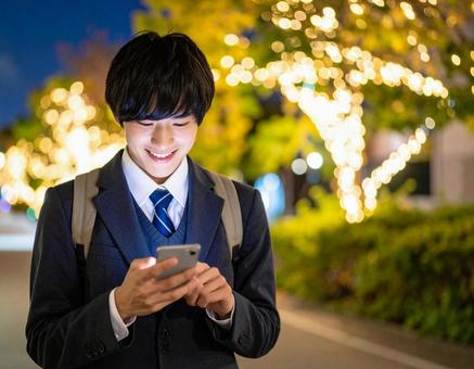 夜道怪しくスマホを操作する男子高校生 夜道怪しくスマホを操作する男子高校生の写真